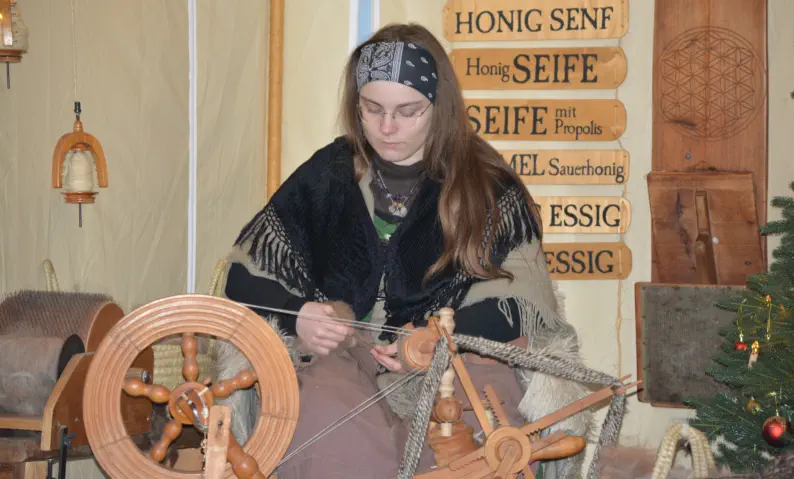 junge Frau am Spinnrad